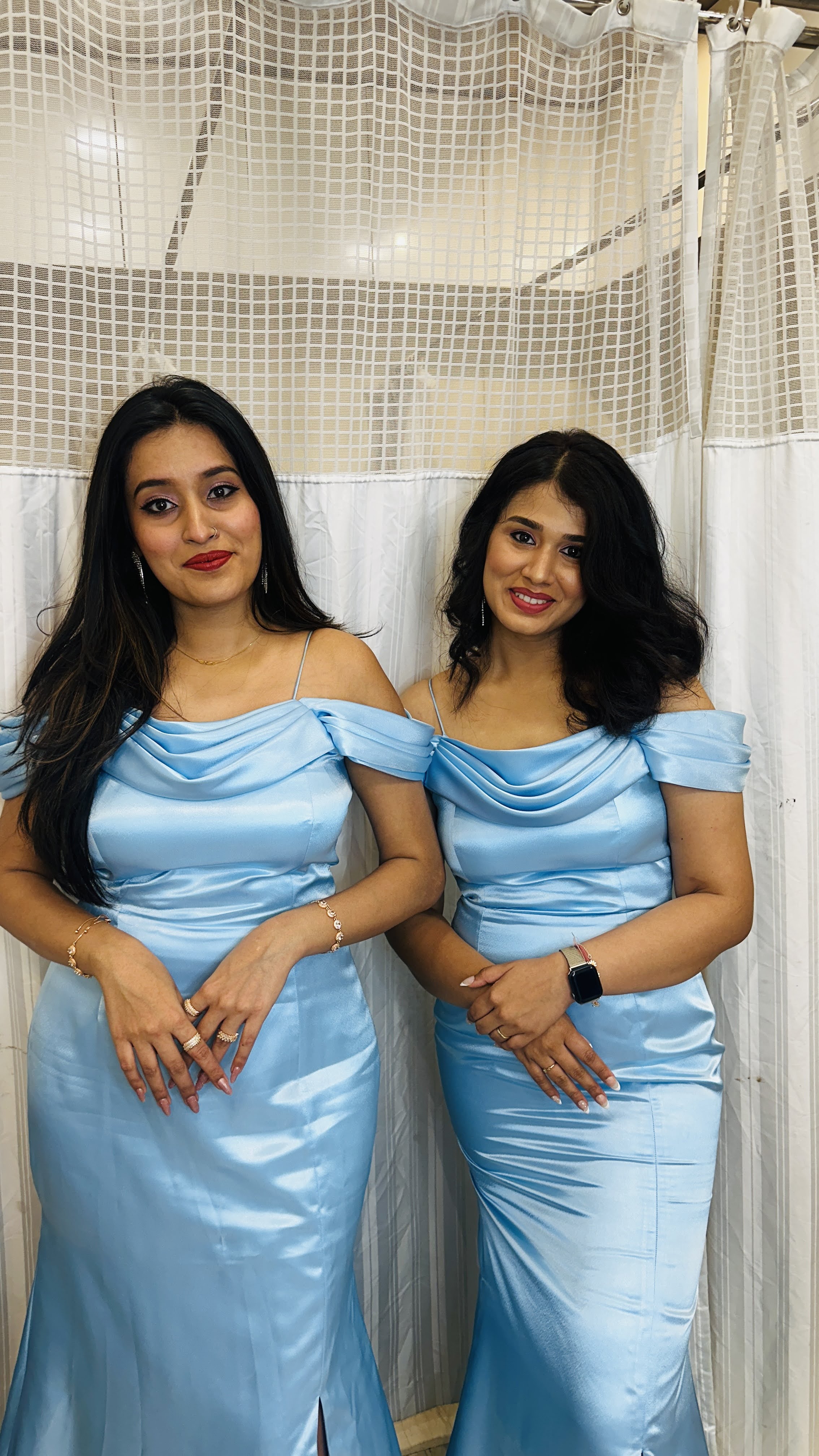 Two smiling women with long, dark, styled hair and elegant makeup, wearing light blue off-shoulder dresses, showcasing beauty services at Seema’s Hair & Skin Clinique in Borivali West.
